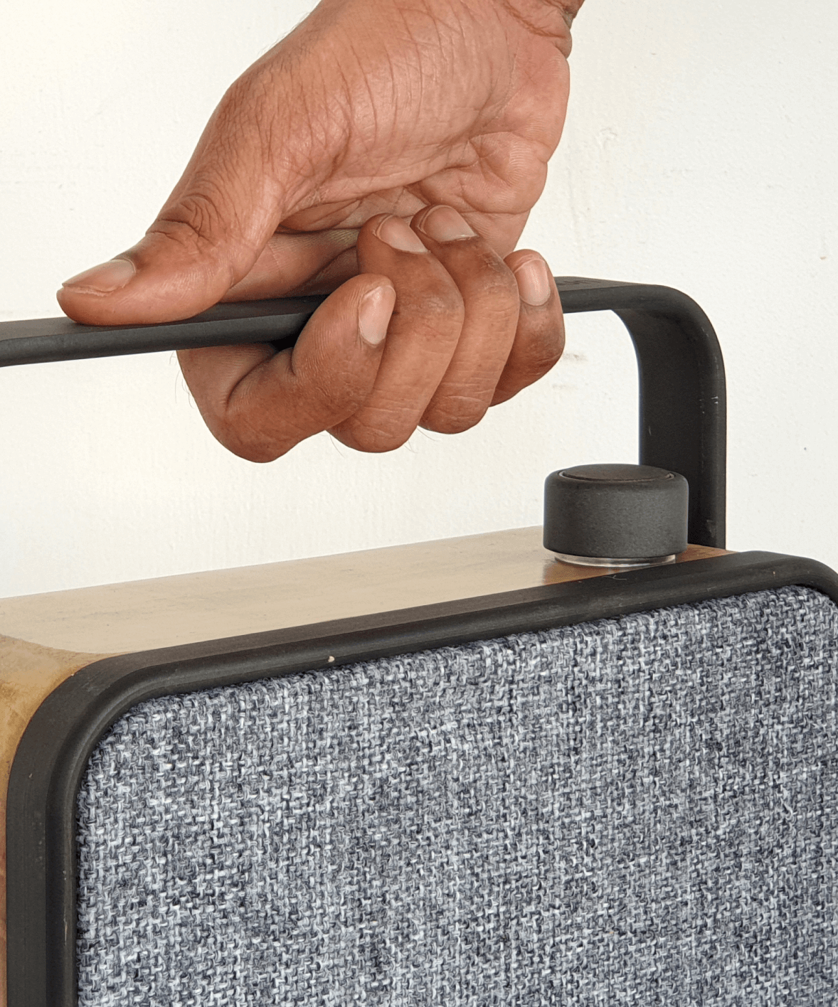 Hand gripping the dhün speaker handle