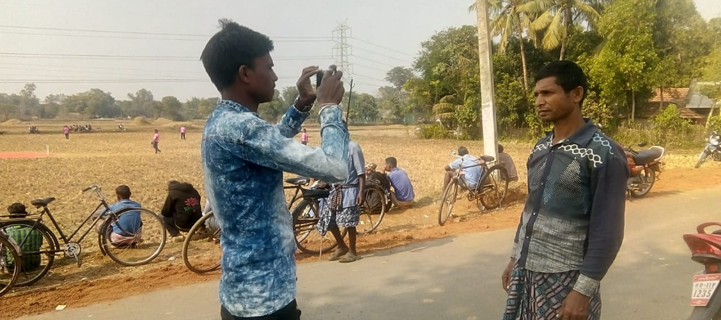 Field staff photographing a resident in a village